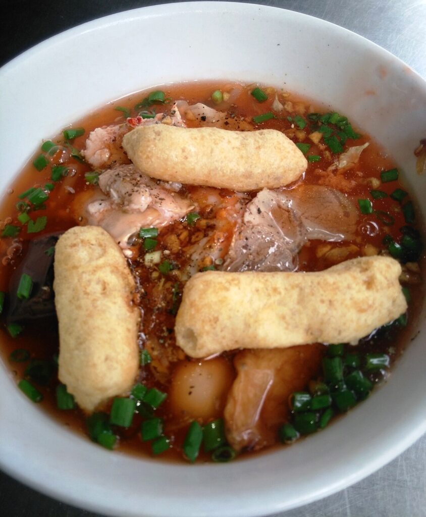 Tô bánh canh với chả chiên vàng ruộm, thịt và hành lá