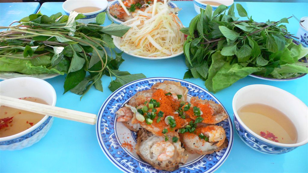 Đĩa bánh khọt tôm rắc bột tôm khô ăn kèm rau sống và đu đủ bào – món ngon khi tìm bánh khọt Nha Trang