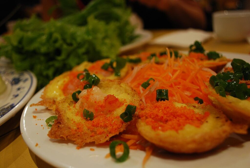 Bánh khọt rắc bột tôm, cà rốt bào và hành lá