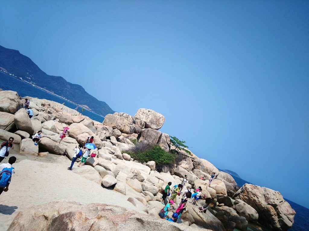 Du khách chụp ảnh trên bãi đá Hòn Chồng, một cảnh đẹp Nha Trang bên biển