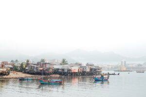 Làng chài ven biển với nhà sàn và thuyền gỗ, khung cảnh giống đảo Bích Đầm Nha Trang