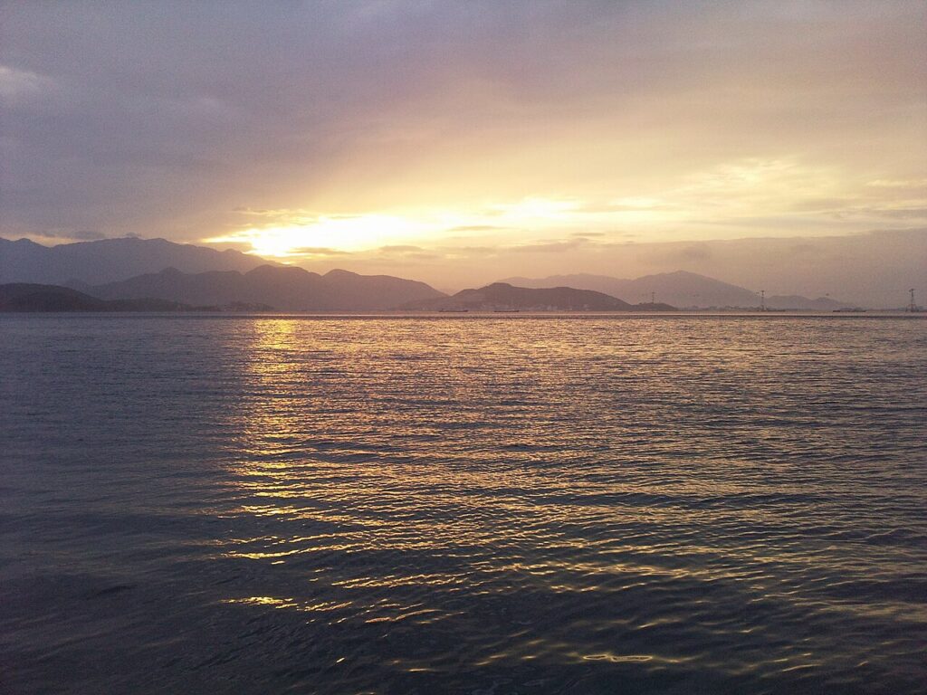 Mặt vịnh Nha Trang lấp lánh ánh nắng dưới dãy núi xa