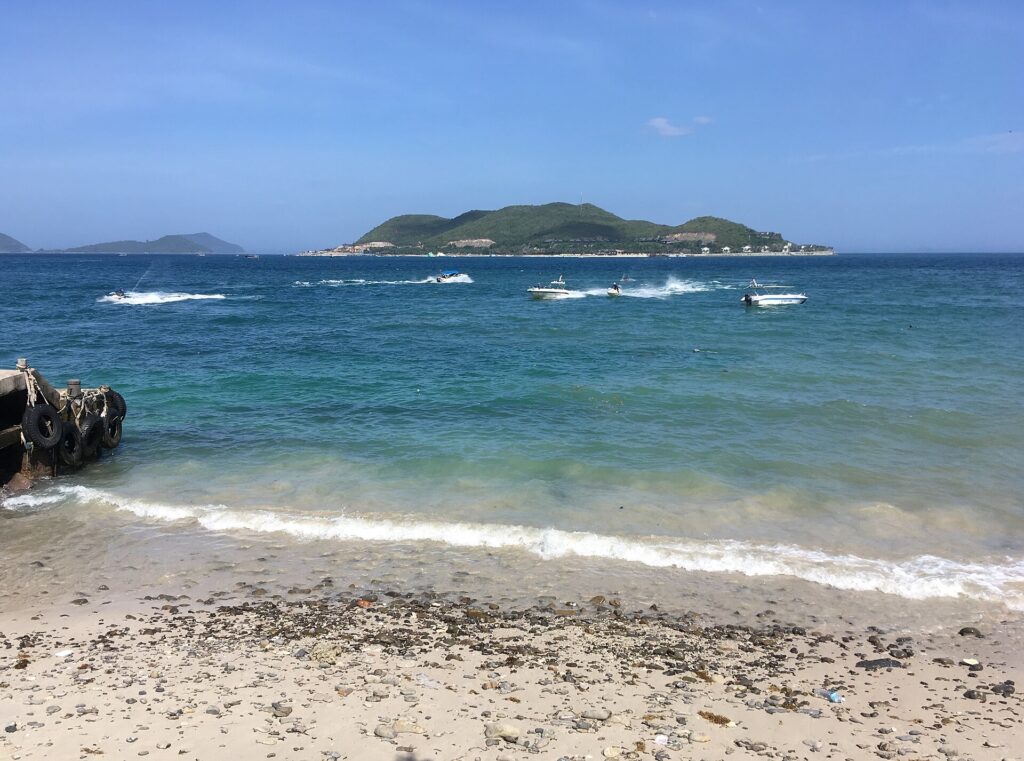 Du thuyền Nha Trang và cano lướt trên vịnh xanh ngọc, phía xa là đảo Hòn Tằm