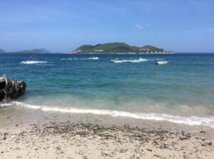 Du thuyền Nha Trang và cano lướt trên vịnh xanh ngọc, phía xa là đảo Hòn Tằm