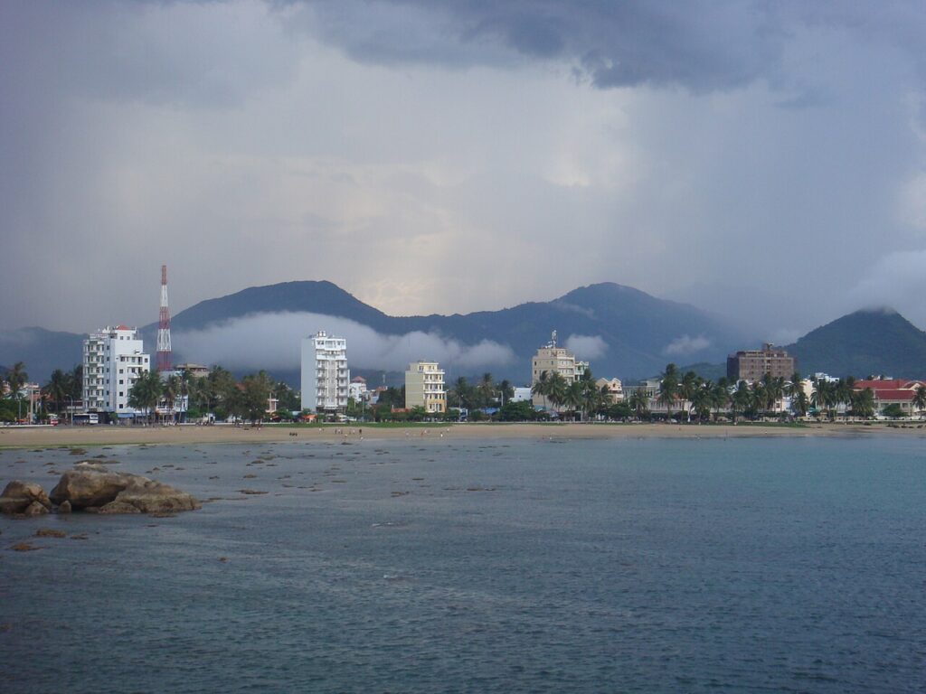 Bờ biển với dãy nhà thấp tầng dưới chân núi ở Nha Trang