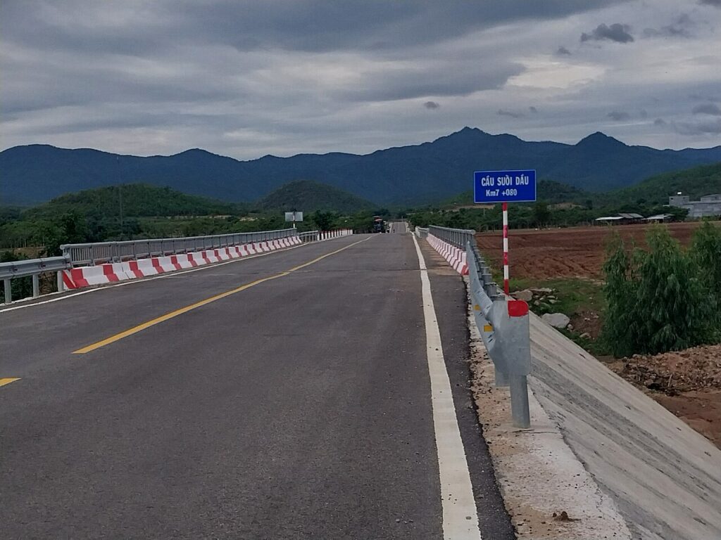 Đường qua cầu Suối Dầu hướng về dãy núi xanh thẫm, cửa ngõ lên Hòn Bà Nha Trang