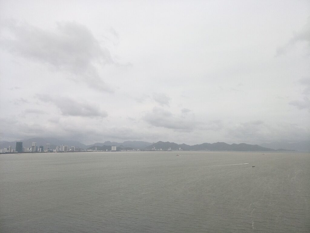 Vịnh Nha Trang ngày mưa với bầu trời xám và dãy núi mờ phía xa