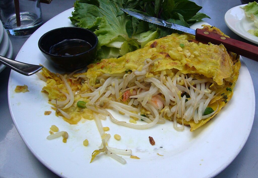 Bánh xèo vàng giòn nhân tôm, giá đỗ, ăn kèm rau sống và nước chấm