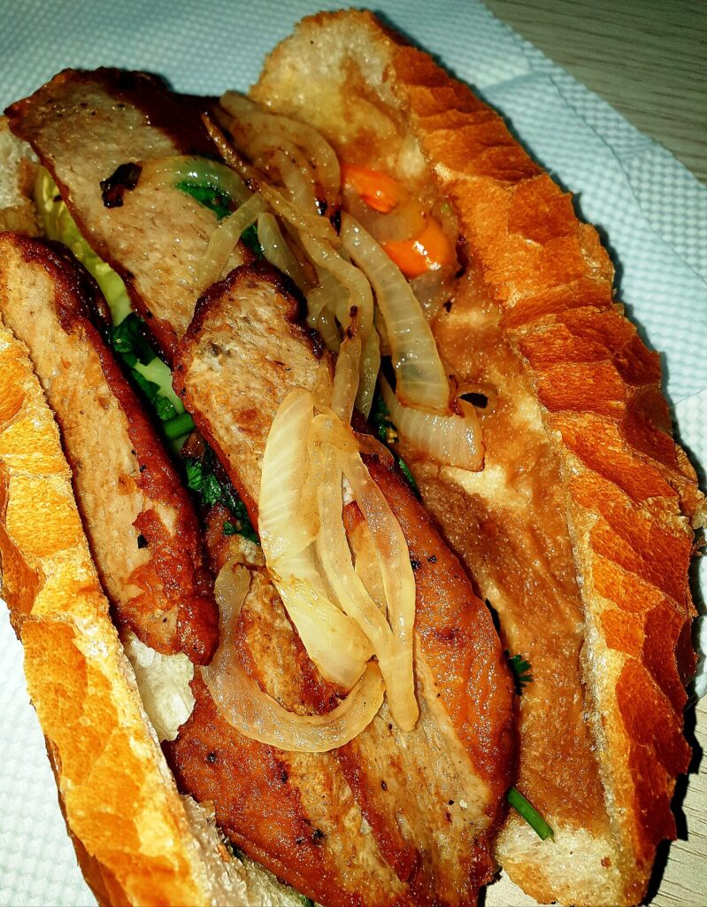 Ổ bánh mì kẹp chả cá chiên và hành tây