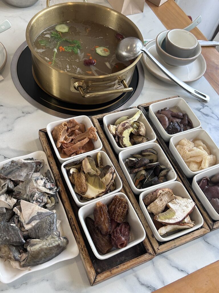 Nồi lẩu nấm chay cùng các khay nấm và đậu hũ ky