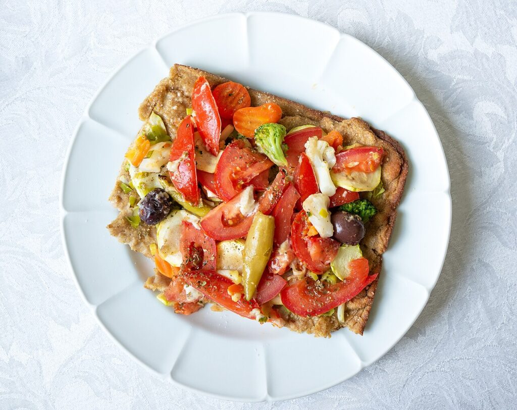 Pizza chay phủ cà chua, bông cải và rau củ tươi