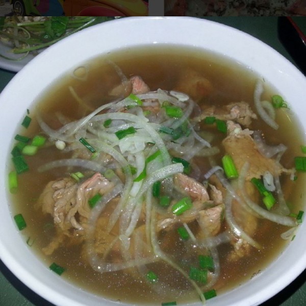 Tô phở bò với thịt thái mỏng, hành tây và hành lá