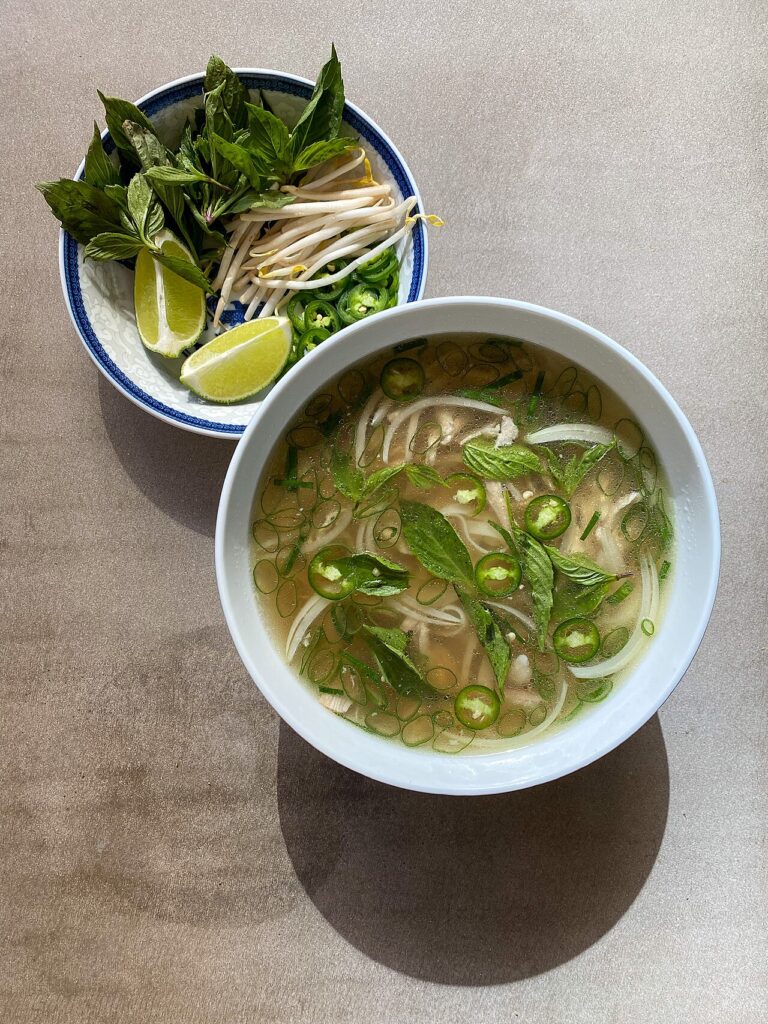 Phở gà kiểu miền Nam ăn kèm húng quế, giá, chanh và ớt
