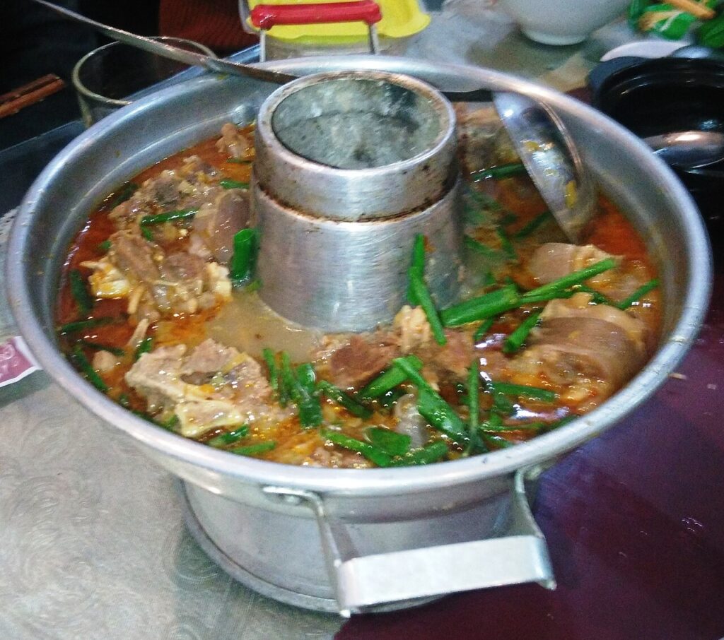 Nồi lẩu dê nóng hổi với xương dê, hành lá, món được gọi nhiều ở các quán dê Nha Trang