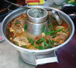 Nồi lẩu dê nóng hổi với xương dê, hành lá, món được gọi nhiều ở các quán dê Nha Trang