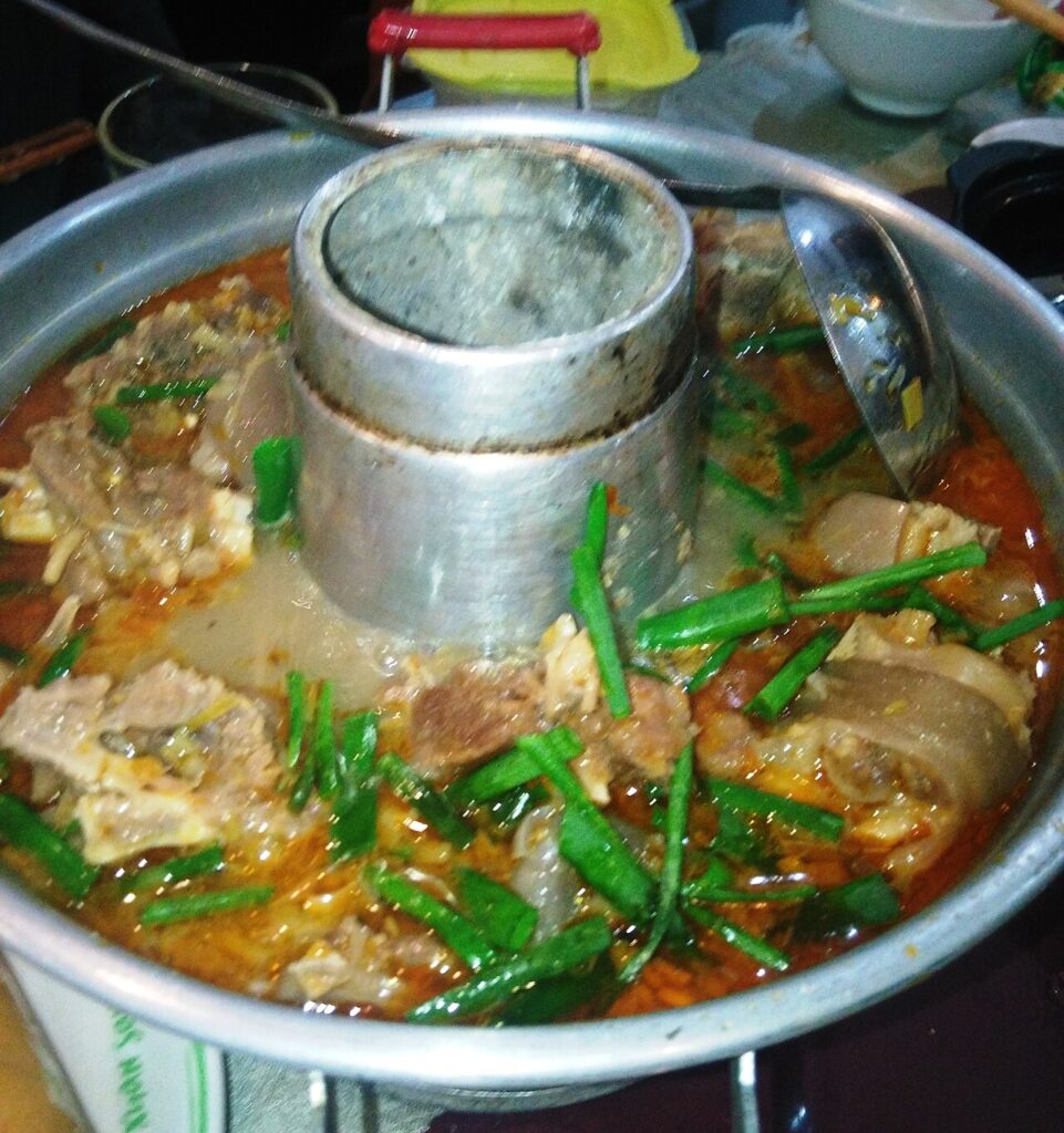 Lẩu dê Nha Trang hầm xương với hành lá, nước dùng đậm đà