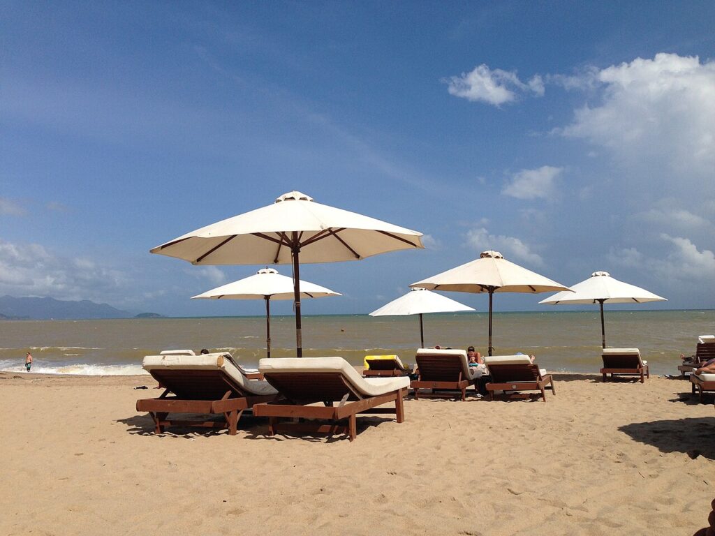 Ghế nằm và dù trắng trên bãi biển khu nghỉ dưỡng Nha Trang