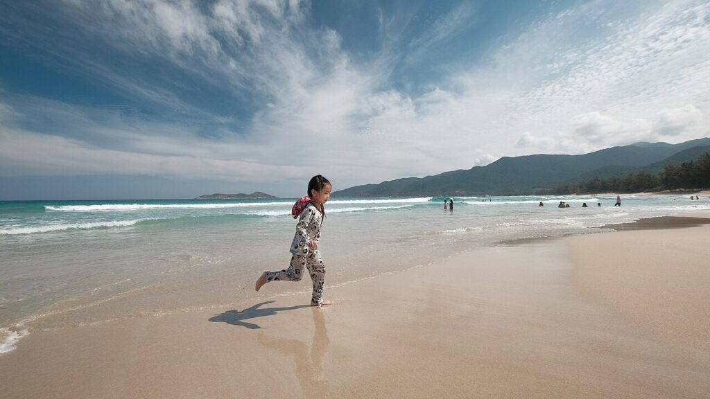 Bé chạy chơi trên bãi biển Cam Ranh, khu resort Nha Trang phía nam