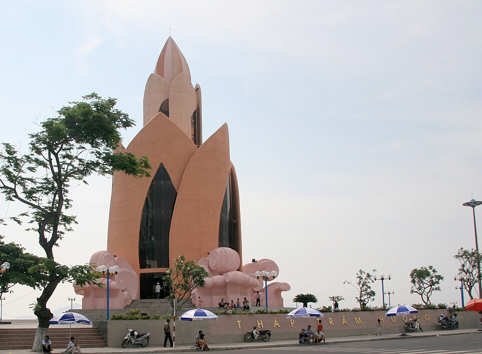 Du khách nghỉ chân dưới dù trước tháp Trầm Hương ở quảng trường Nha Trang